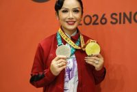 Kris Dayanti memamerkan dua medali yang diraihnya di Singapore Kung Fu Games.